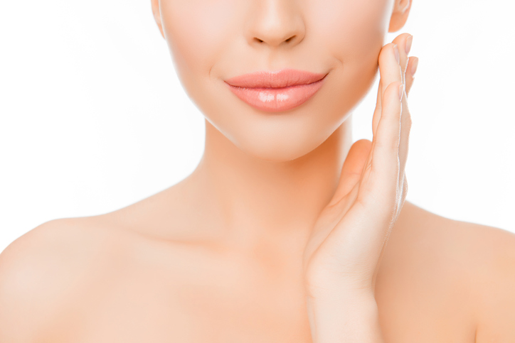 woman with perfect skin applying cream on face