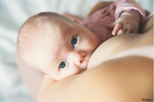 Mother breastfeeding with breast augmentation