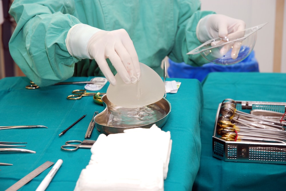Nurse with operating tools and breast implant.