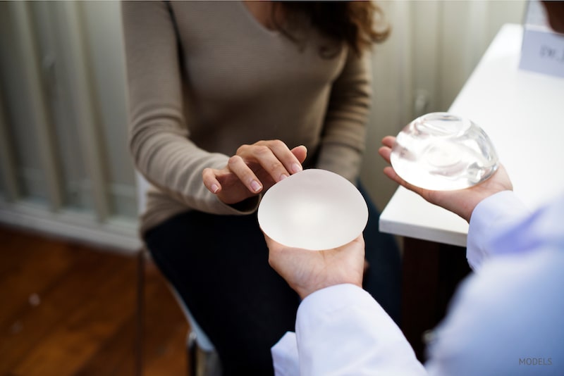 woman choosing between textured and smooth breast implants