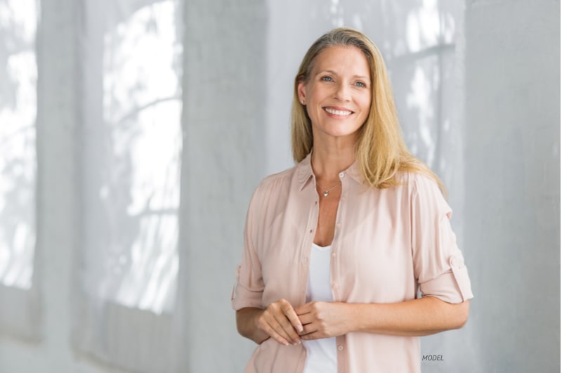 Attractive middle-aged woman smiling as she looks away from the camera