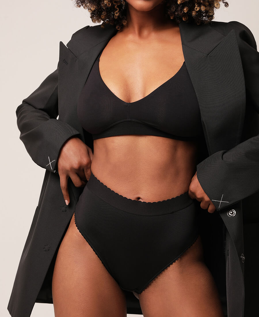 Woman in a black coat with her hands on her hips