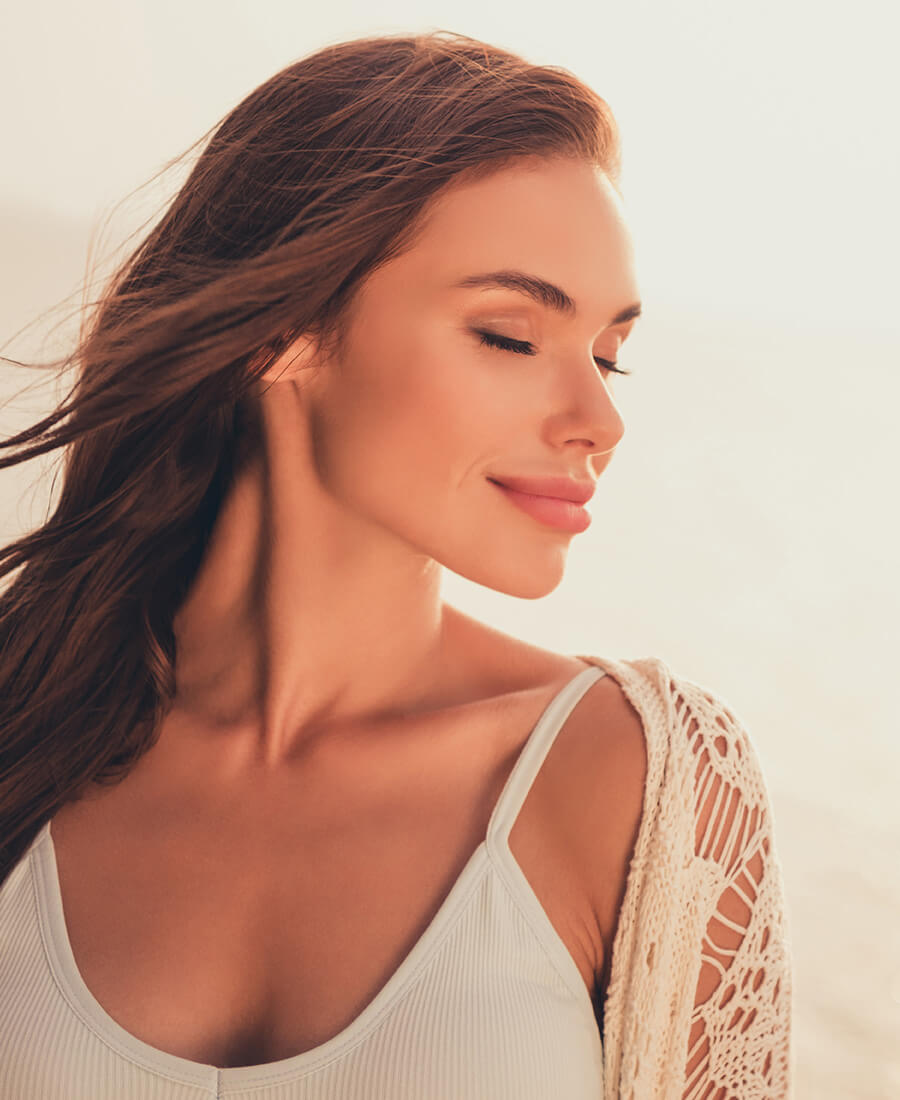Woman at the beach at sunset