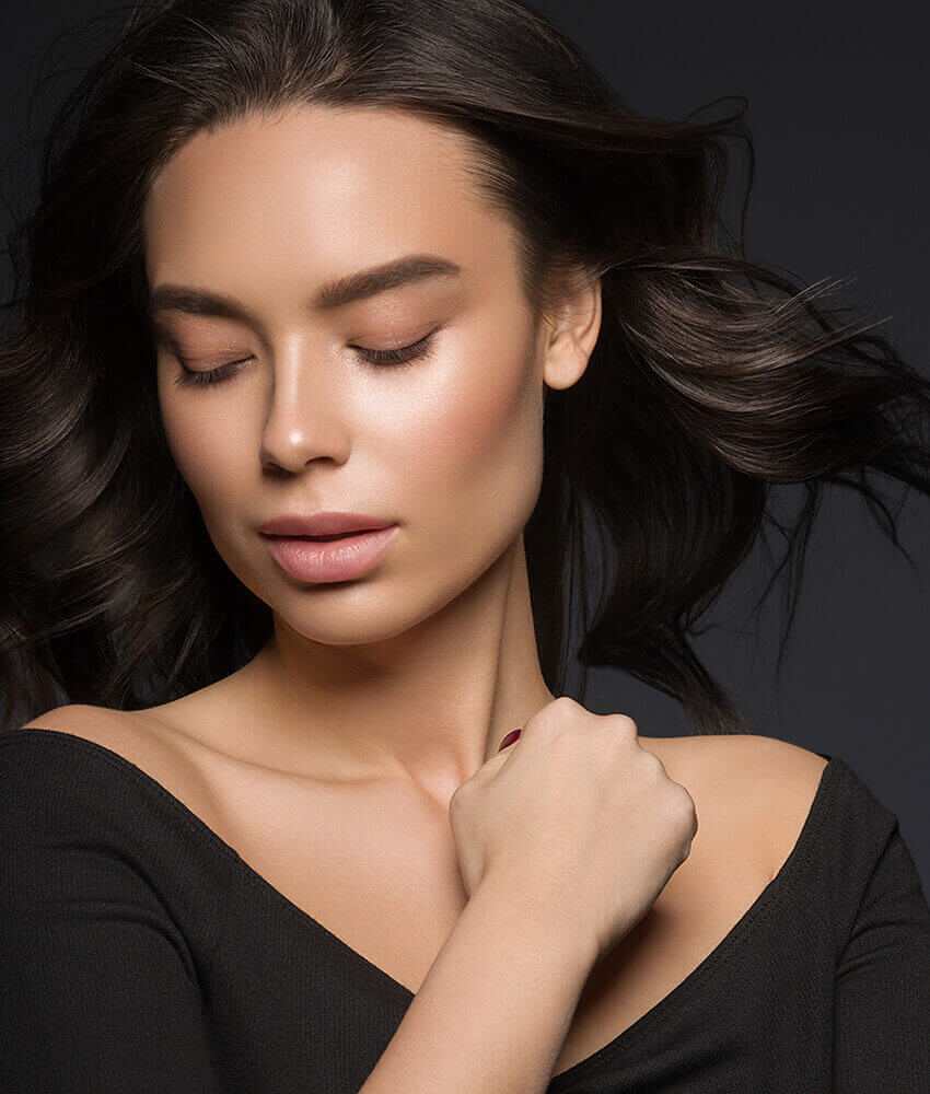 Woman with black hair and glowing skin